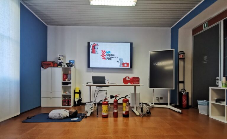 Aula di formazione attrezzata con schermo, lavagna digitale, manichino ed estintori
